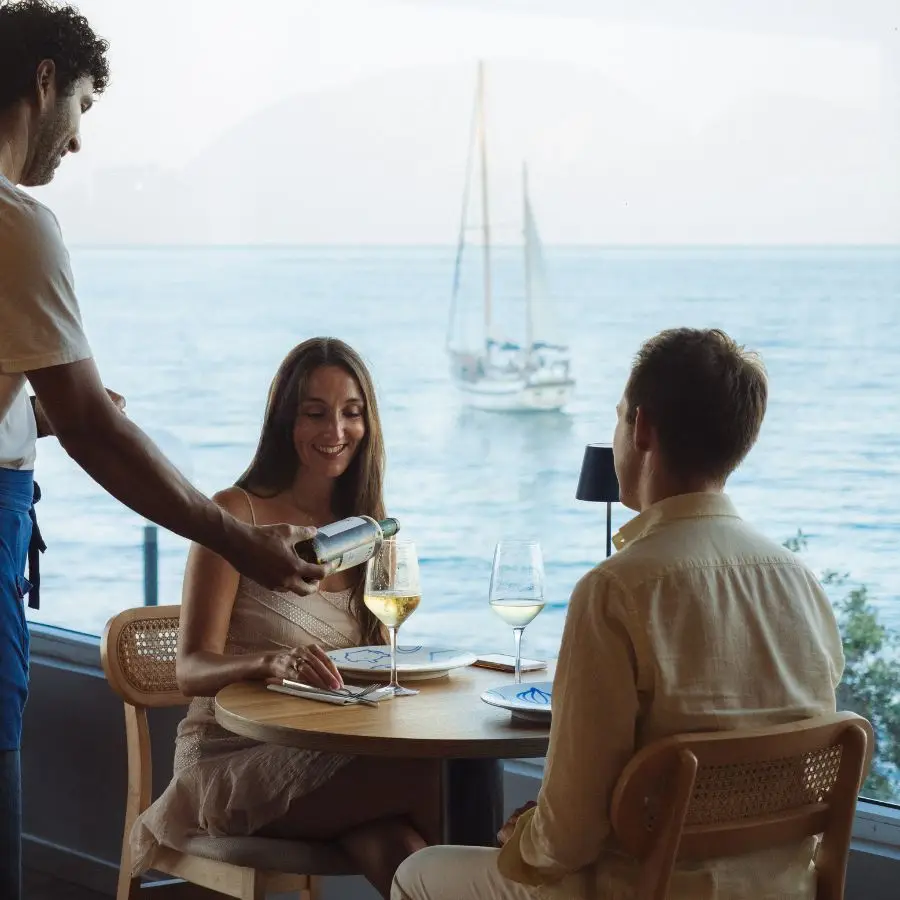 Two guests enjoying a meal at COR with the sea in the background